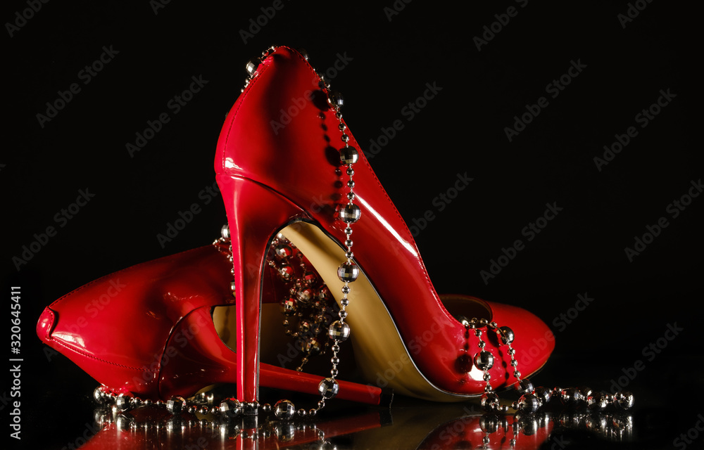 patent leather shiny female red stilettos and beads on a black ...