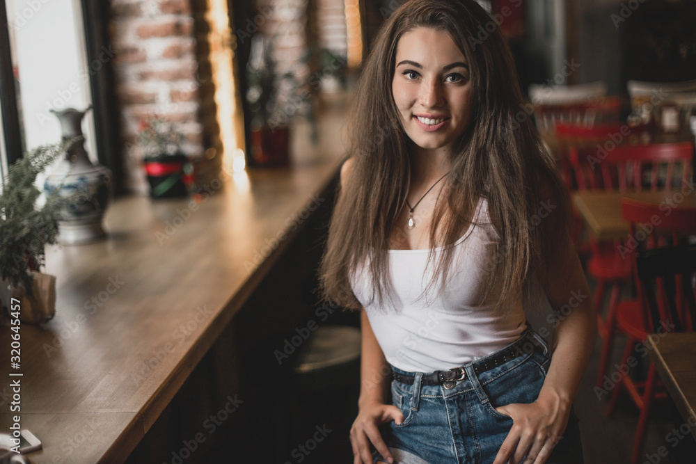 Beautiful woman posing for the camera sitting in a cafe.