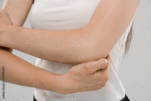 Wallpaper Mural Woman showing pain in elbow. Torontodigital.ca