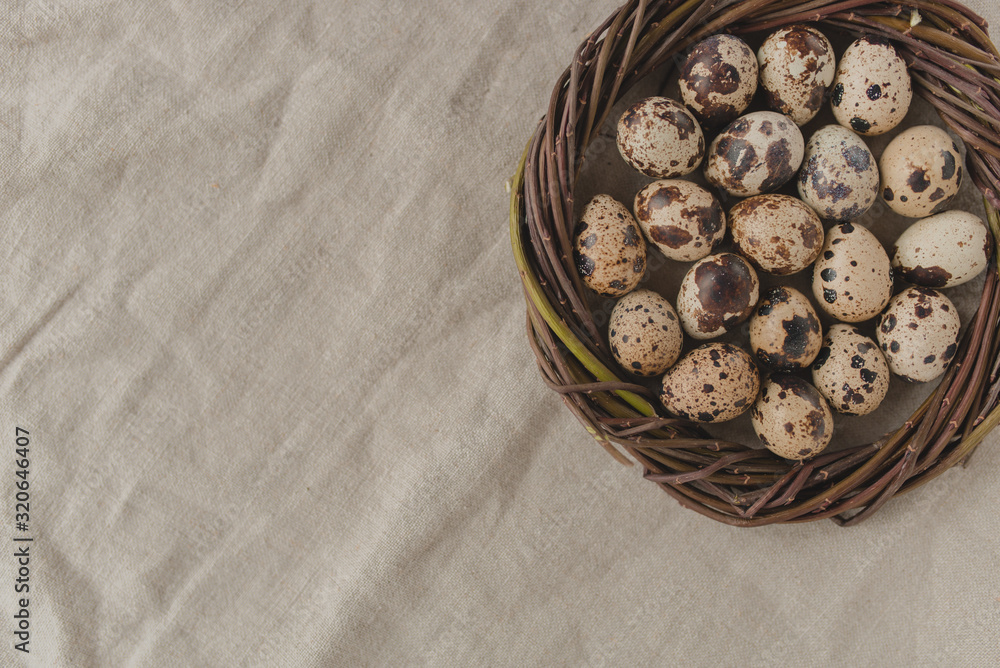 Quail eggs in a nest on a rustic style linen background. Easter and healthy eating concept. Flat lay style. Quail eggs in a nest on a rustic style linen background. Easter and healthy eating concept. Flat lay style.