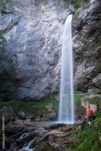 Man with orange jacket on waterfall Wildensteiner Wasserfall Gallicia, Austria photo