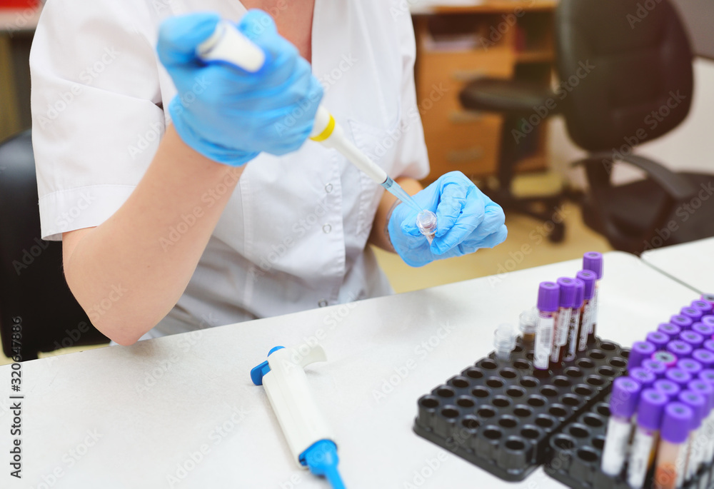 scientist in a medical laboratory with a dispenser in his hands is doing an analysis