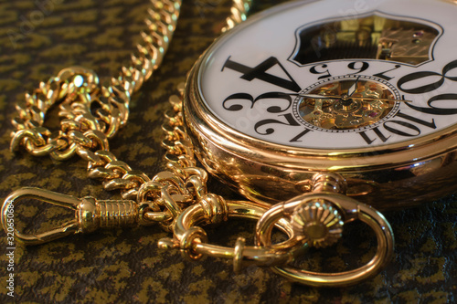 An old gold pocket watch with a watch and a musical mechanism.