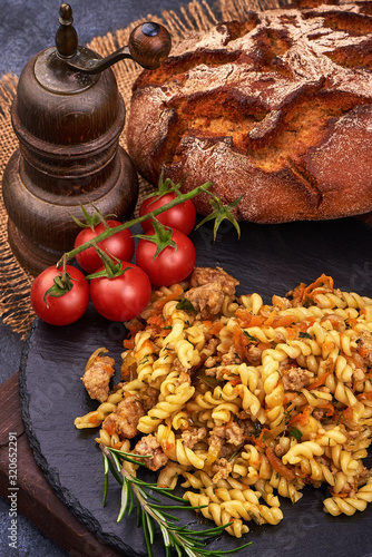 Fusilli pasta with minced meat on rustic background photo