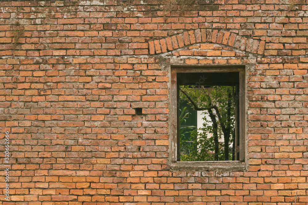 Old brick wall with a window and trees behind Old brick wall with a window and trees behind