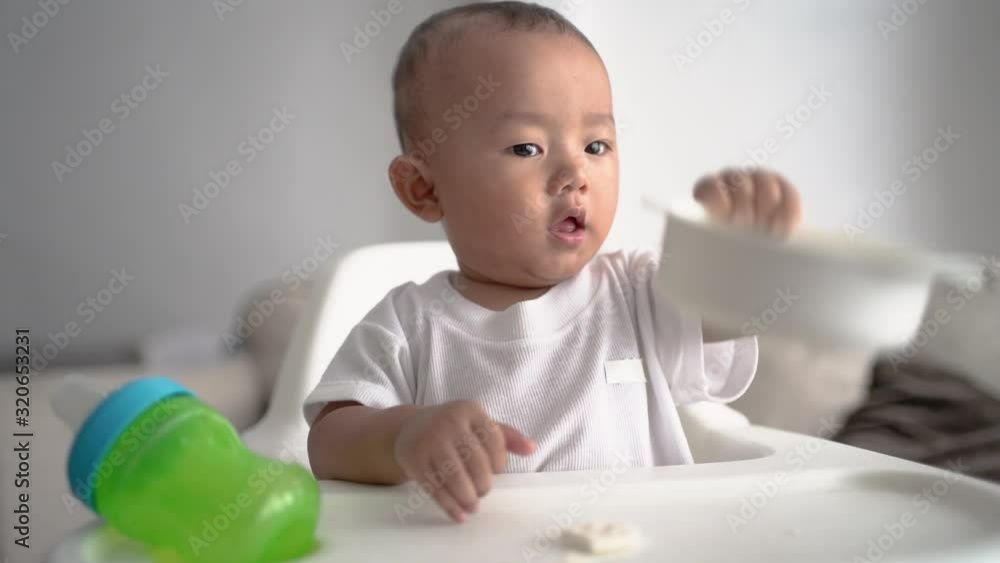 happy asian baby boy sitting on high chair smiling happy asian baby boy sitting on high chair smiling