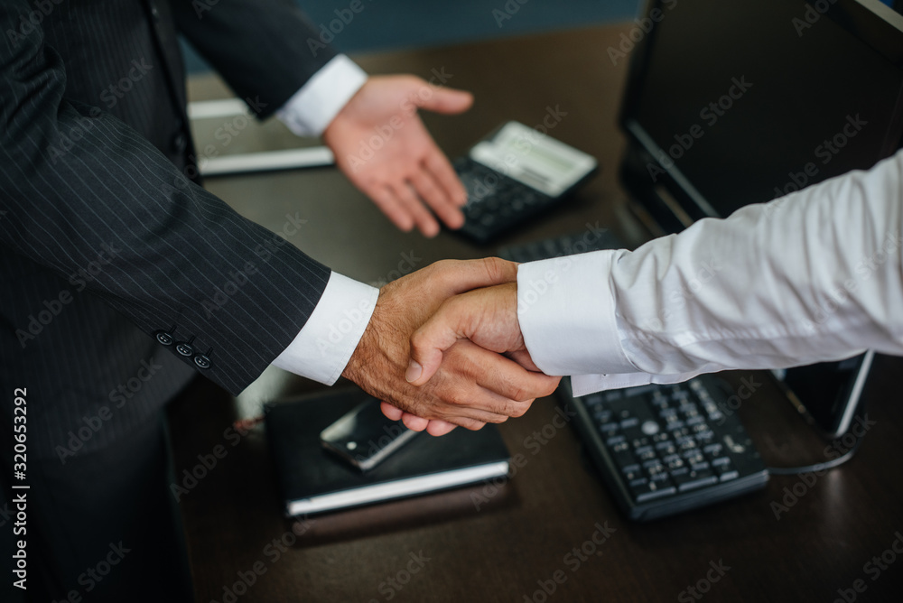 Close-up of the partners ' handshake, completion of the transaction in the office. Business Close-up of the partners ' handshake, completion of the transaction in the office. Business
