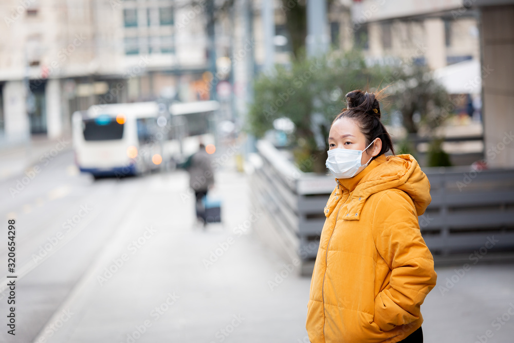 The image of a young Asian woman wearing a mask to prevent germs, toxic fumes, and dust. Prevention of bacterial infection in the air around the streets and gardens. The image of a young Asian woman wearing a mask to prevent germs, toxic fumes, and dust. Prevention of bacterial infection in the air around the streets and gardens.