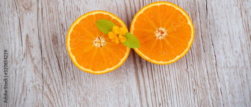 Natural fresh fruit oranges in a wooden background backdrop  half cut oranges  orange juice  vitamin C  for good health everyday