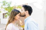 Man Kissing Forehead Of Girlfriend Outside Cafe
