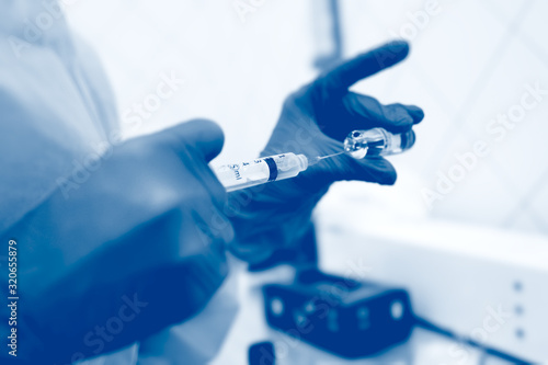 the doctor holds in his hand a syringe with plasma or with a close-up injection for hair regeneration and skin rejuvenation