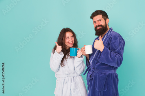 Vacation starting here. Man and woman happy together. Family traditions. Couple in cozy bathrobes enjoy lazy weekend. Drinking coffee. Spa and relax. Hotel breakfast service. Coffee is our tradition