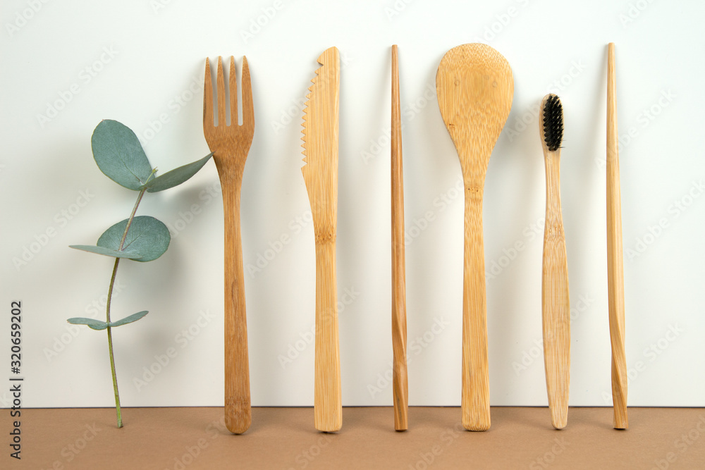 Eco friendly bamboo cutlery set and eucalyptus leaves on a white background. Zero waste concept. Eco friendly bamboo cutlery set and eucalyptus leaves on a white background. Zero waste concept.
