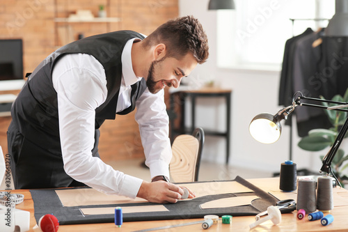 Young tailor working at tab...