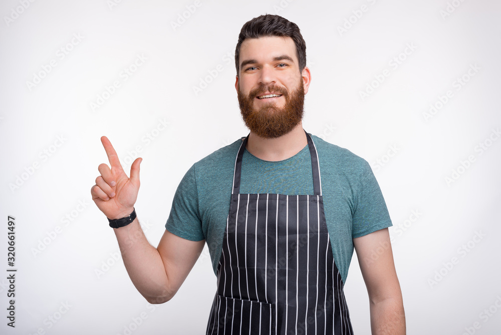 Photo of young bearded Chef pointing away at copyspace Photo of young bearded Chef pointing away at copyspace