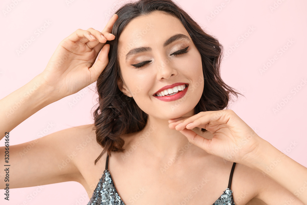 Beautiful young woman with stylish makeup on color background