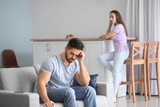 Upset young couple after quarrel at home