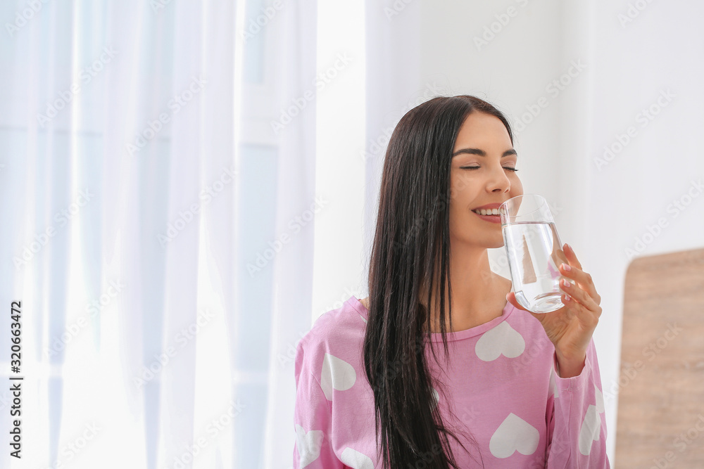 Morning of beautiful young woman drinking water in bedroom Morning of beautiful young woman drinking water in bedroom