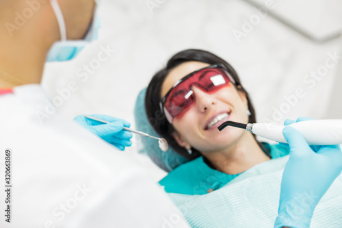 Cute young girl is being examined by the dentist