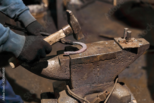 blacksmith forges a horseshoe, close-up