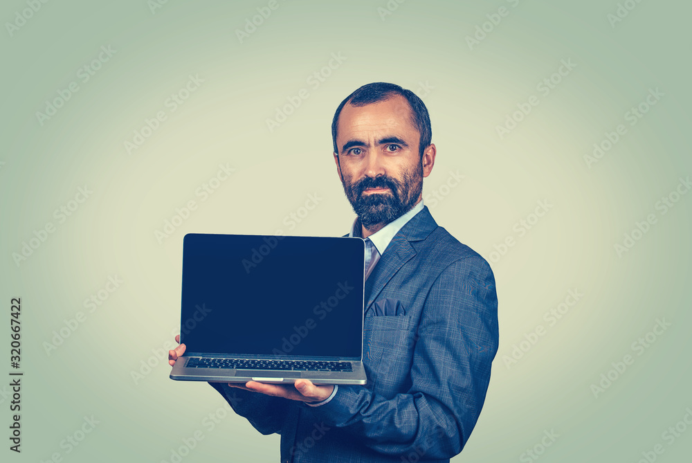 Bearded business man showing blank black laptop screen Bearded business man showing blank black laptop screen