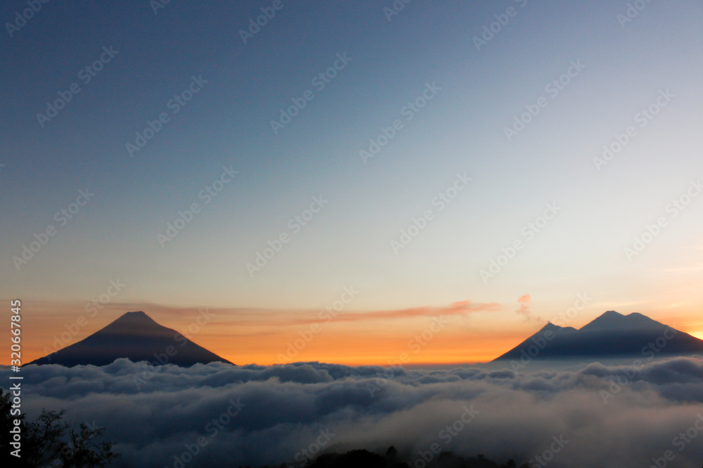 Sunset over Volcano of Fire, Acatenango Volcano and Water Volcano - volcanoes surrounded by clouds - A view of the volcanoes of Guatemala