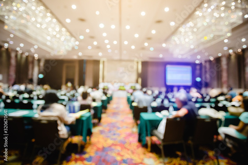 Fotografie Blurry business man and woman sitting with chairman of the meeting and executive committee background in auditorium for shareholders meeting or seminar event, Annual shareholder meeting