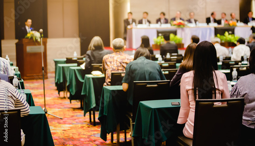 Tableau sur toile Selective focus to business woman sitting with blurry chairman of the meeting and executive committee background in auditorium for shareholders meeting or seminar event, Annual shareholder meeting