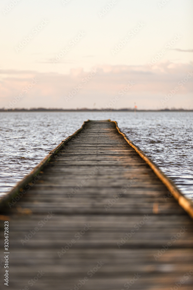 Holzsteg im Meer im Sonnenuntergang