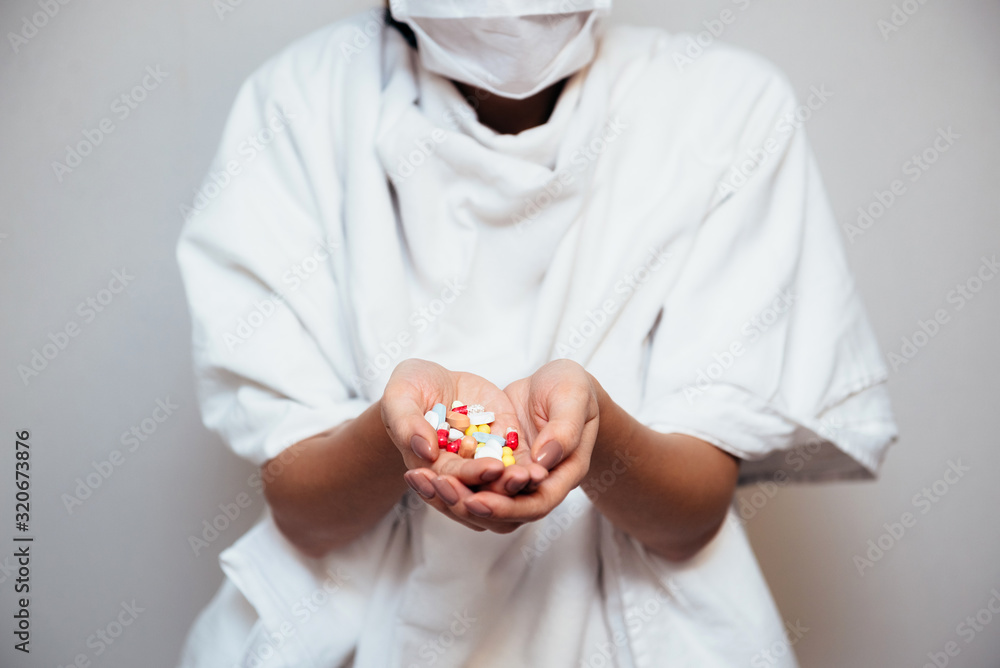 The girl holds a handful of different pills in her palms. The girl holds a handful of different pills in her palms.