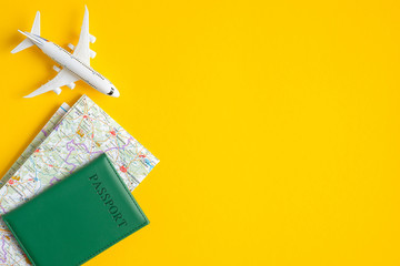 Summer travel concept. Flat lay traveler accessories on yellow background with copy space. Top view plane, passport, map. Travel agency banner design template