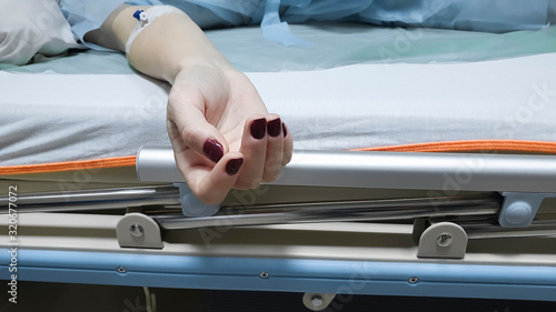 Tableau sur toile Close-up of female hands with a catheter, which lies on a hospital bed