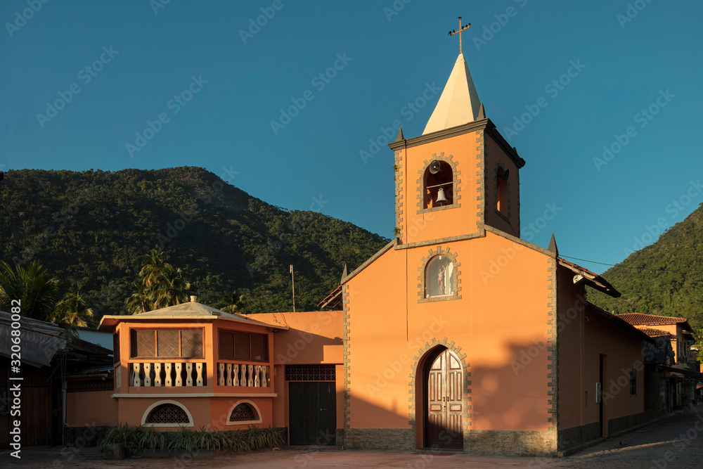Abraao village center with ancient Catholic church and mountain in the background, Ilha Grande, Rio de Janeiro, Brazil Abraao village center with ancient Catholic church and mountain in the background, Ilha Grande, Rio de Janeiro, Brazil