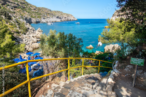 Fototapeta Naklejka Na Ścianę i Meble -  Concrete stairs with rails to small beach in Anthony Quinn bay (Rhodes, Greece)