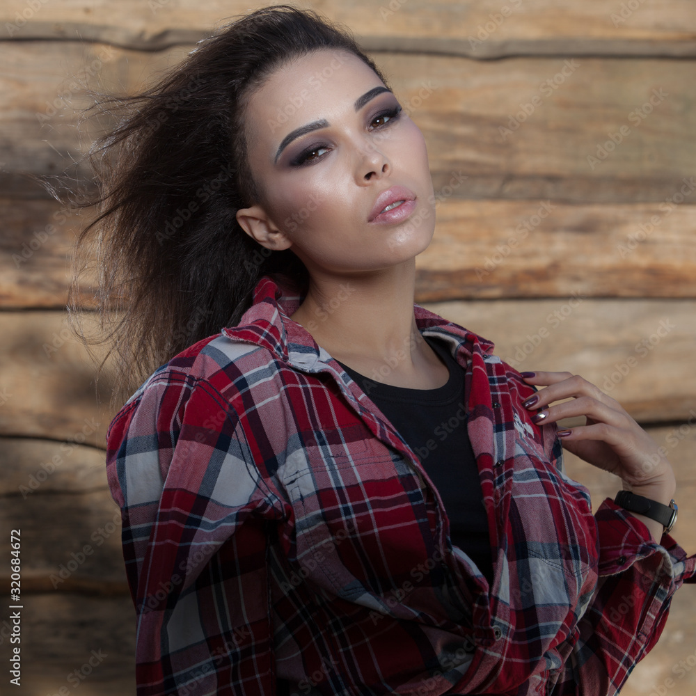 Naklejka premium Portrait of beautiful young girl on wooden background.