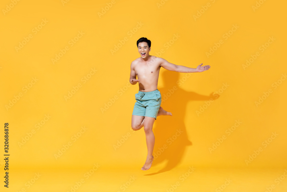 Energetic smiling shirtless handsome Asian man jumping