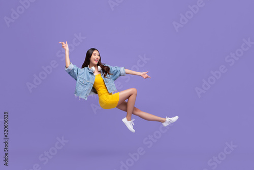 Young beautiful smiling Asian girl floating in mid-air