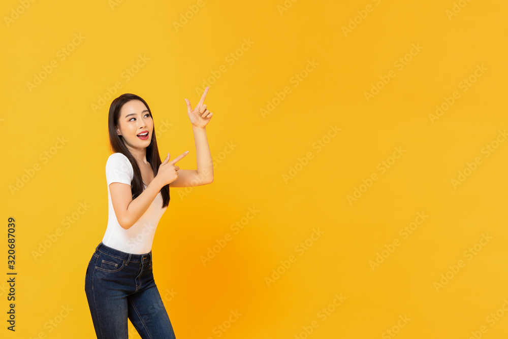 Young beautiful smiling Asian woman pointing up with her two fingers Young beautiful smiling Asian woman pointing up with her two fingers