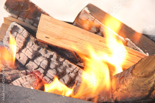 log in the flames. burning fire in the grill is large. 