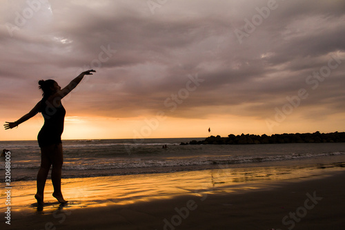 silhouette of young dancer woman at sunset