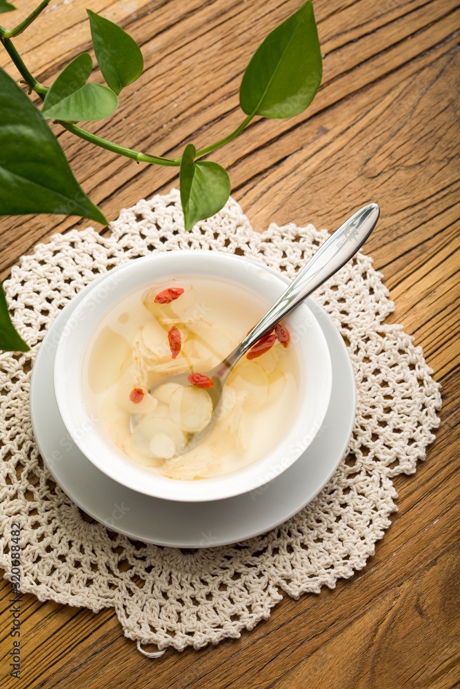 Ginseng has medicinal properties against a white background and can be dipped in water and sliced, also known as American ginseng-Panax quinquefolius