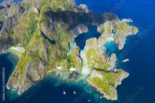 View from above, aerial view of the Big Lagoon and the Small Lagoon, two beautiful bays of crystal clear water surrounded by rocky cliffs. Miniloc Island, Bacuit Bay, El Nido, Palawan, Philippines. © Travel Wild