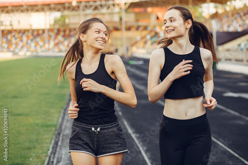 Beautiful girls at the stadium. Sports girl in a sportswear. Frends training