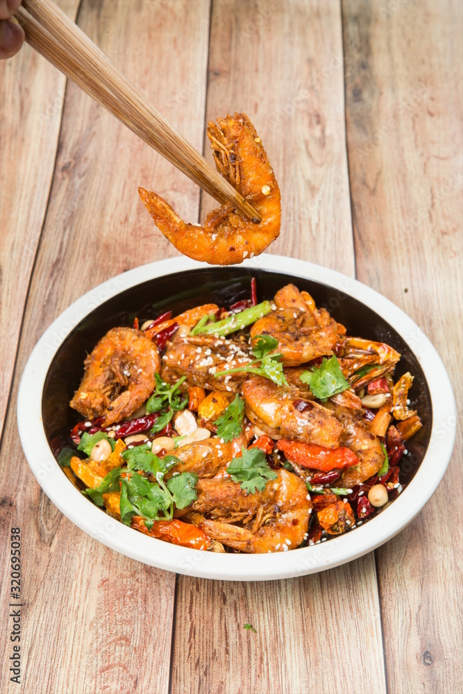 This is an Asian cuisine where you take the shrimp and you fry it, you add the chili, the white sesame, the sichuan peppercorn and then you pour the beer inside