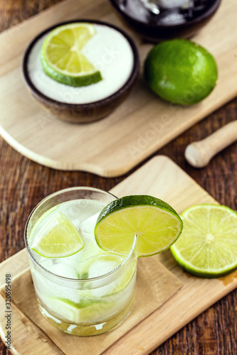 Caipirinha, drink from Brazil, typical of the Brazilian summer. Fruit drink with vodka or cachaça, on rustic wooden background and space for text.
