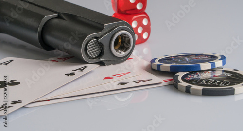 Poker chips, cards and gun on a white background. The concept of gambling and entertainment. Casino and poker