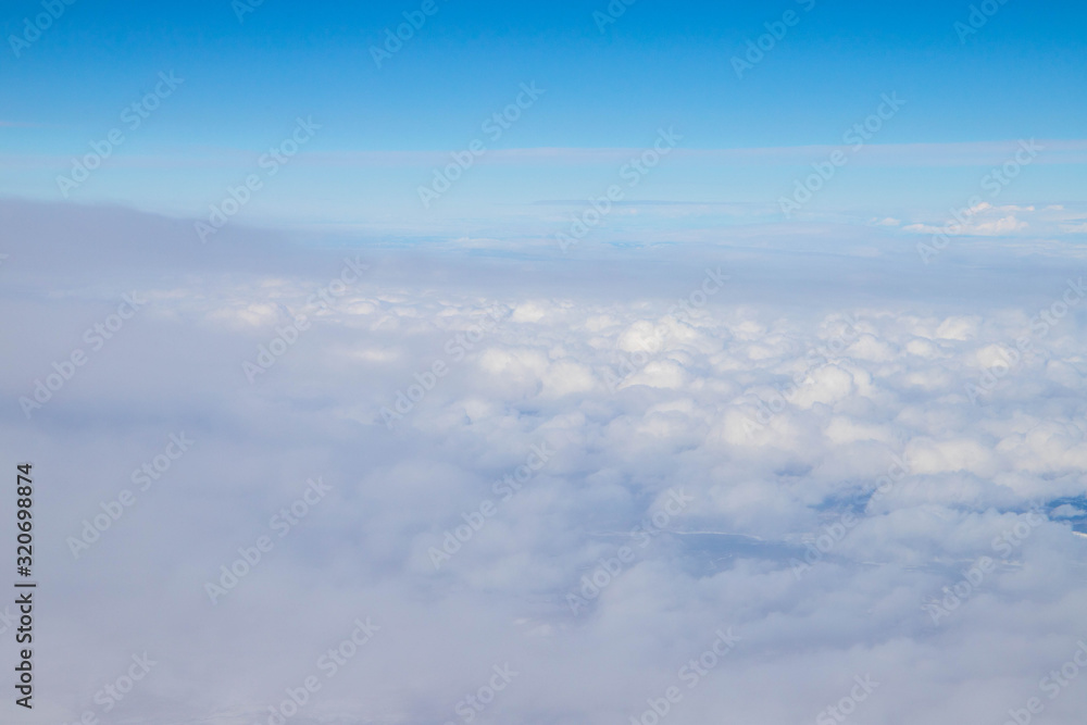View of the white clouds and blue sky from the airplane 