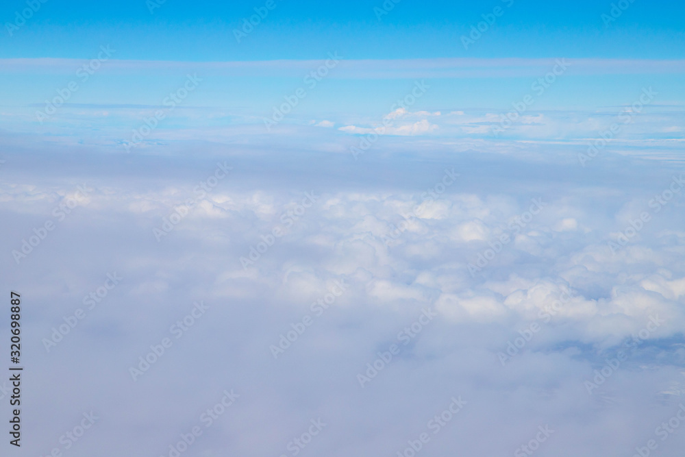 View of the white clouds and blue sky from the airplane 