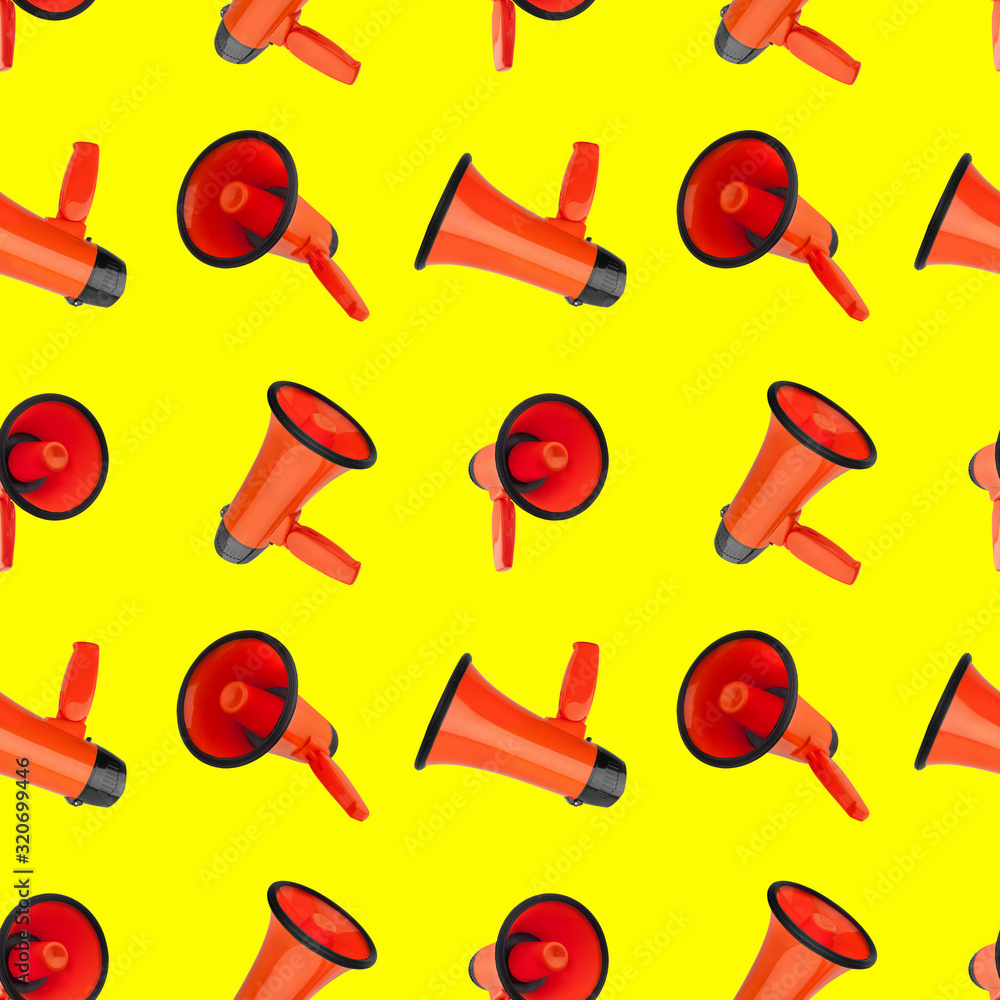 Seamless pattern of orange megaphones on yellow background isolated