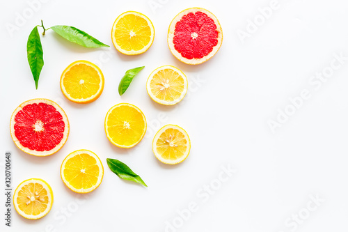 Citrus slices frame - lemons  grapefruits  leaves - on white background top-down copy space